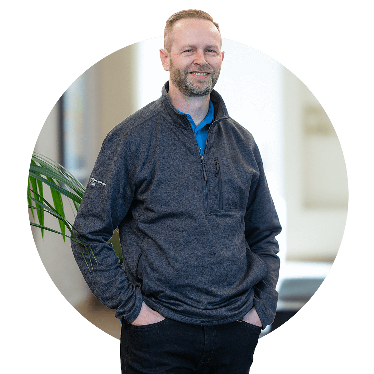 A male Bank employee stands in the building lobby smiling and looking toward the camera.