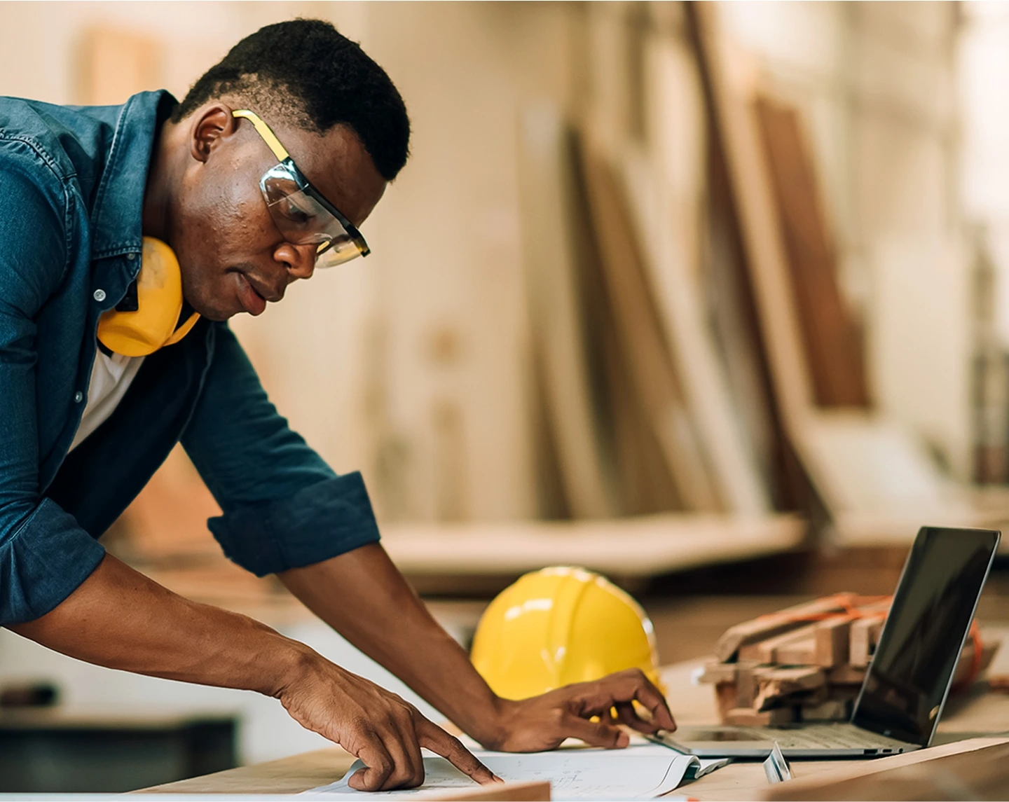 A contractor on the site of a remodel project checks blueprints for the project he is working on.